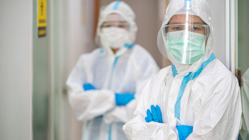 Two Healthcare workers in PPE looking at camera